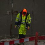 A frontline worker wearing compliant high-vis industrial workwear issued through a corporate uniform allowance program.