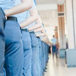 Group of employees in matching blue corporate uniforms demonstrating the scale of a managed uniform program via Get WorkGear.