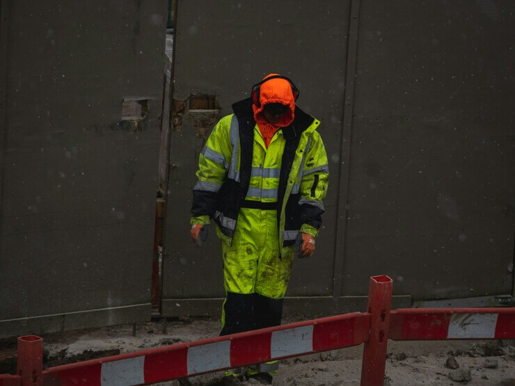 A frontline worker wearing compliant high-vis industrial workwear issued through a corporate uniform allowance program.